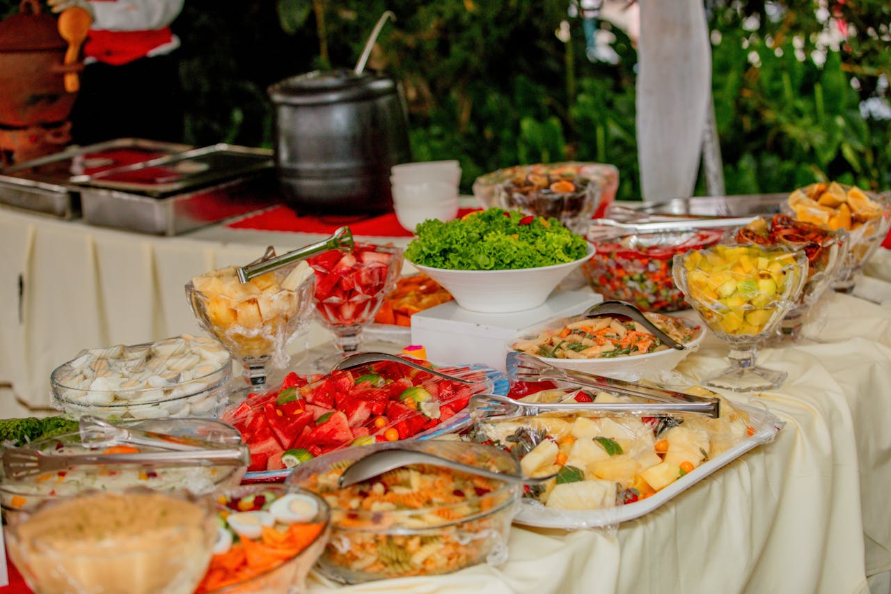 Colorful assorted dishes on an outdoor buffet table ready to serve at a gathering.