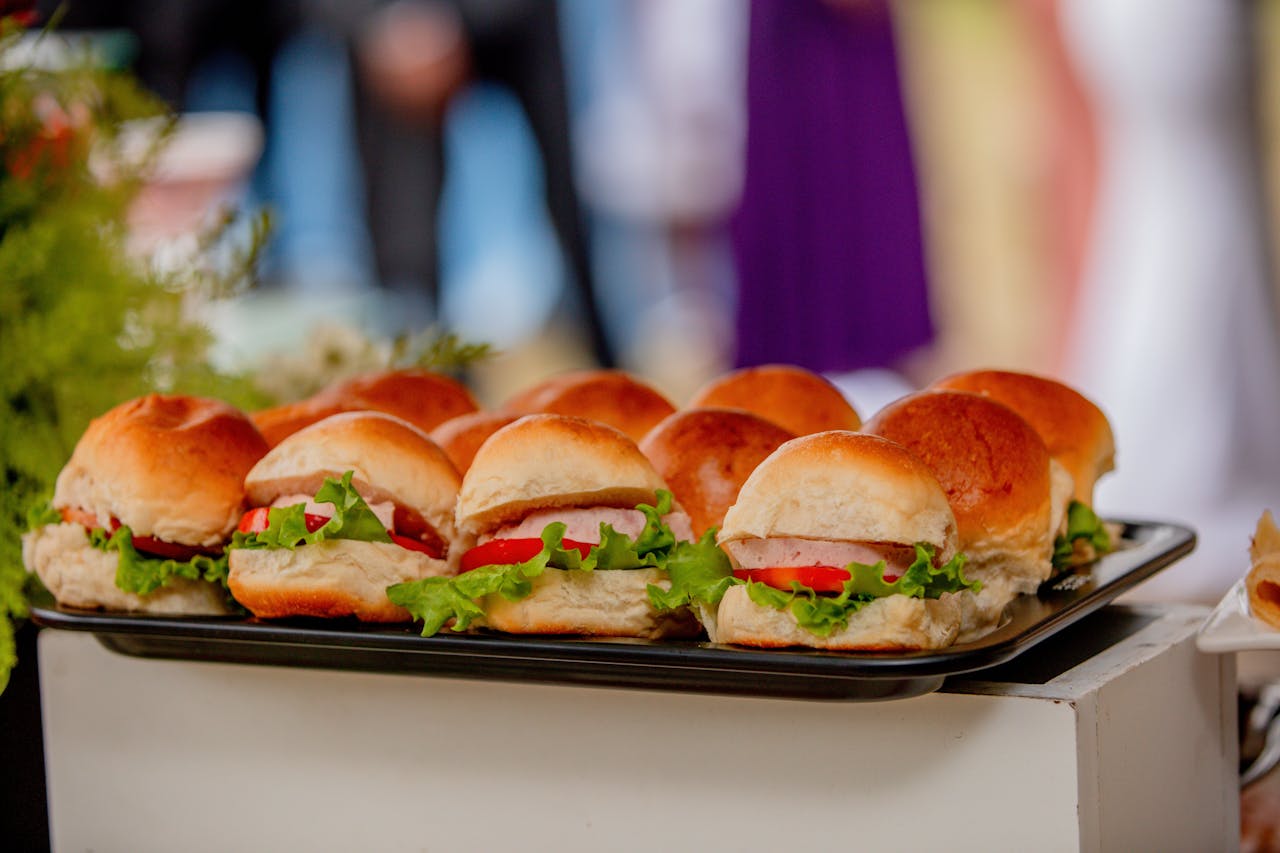 Fresh mini sandwiches with lettuce and tomato, perfect for events or gatherings.