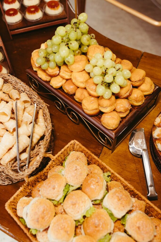 Delicious buffet setup featuring savory pastries, fresh grapes, and small sandwiches in an elegant presentation.