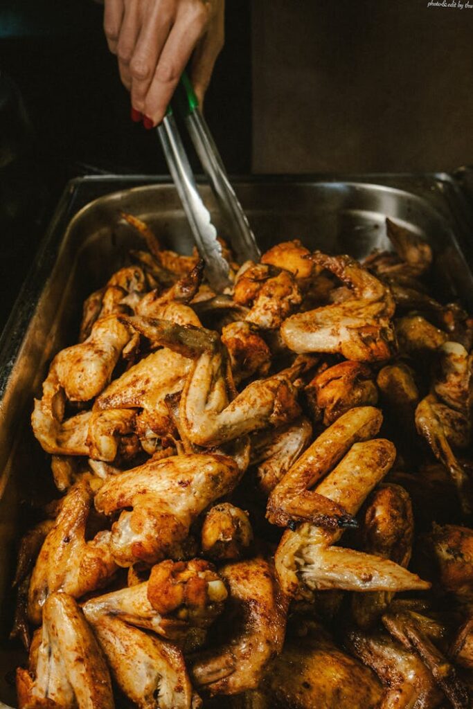 Delicious roasted chicken wings being served in a catering setup. Ideal for parties and gatherings.